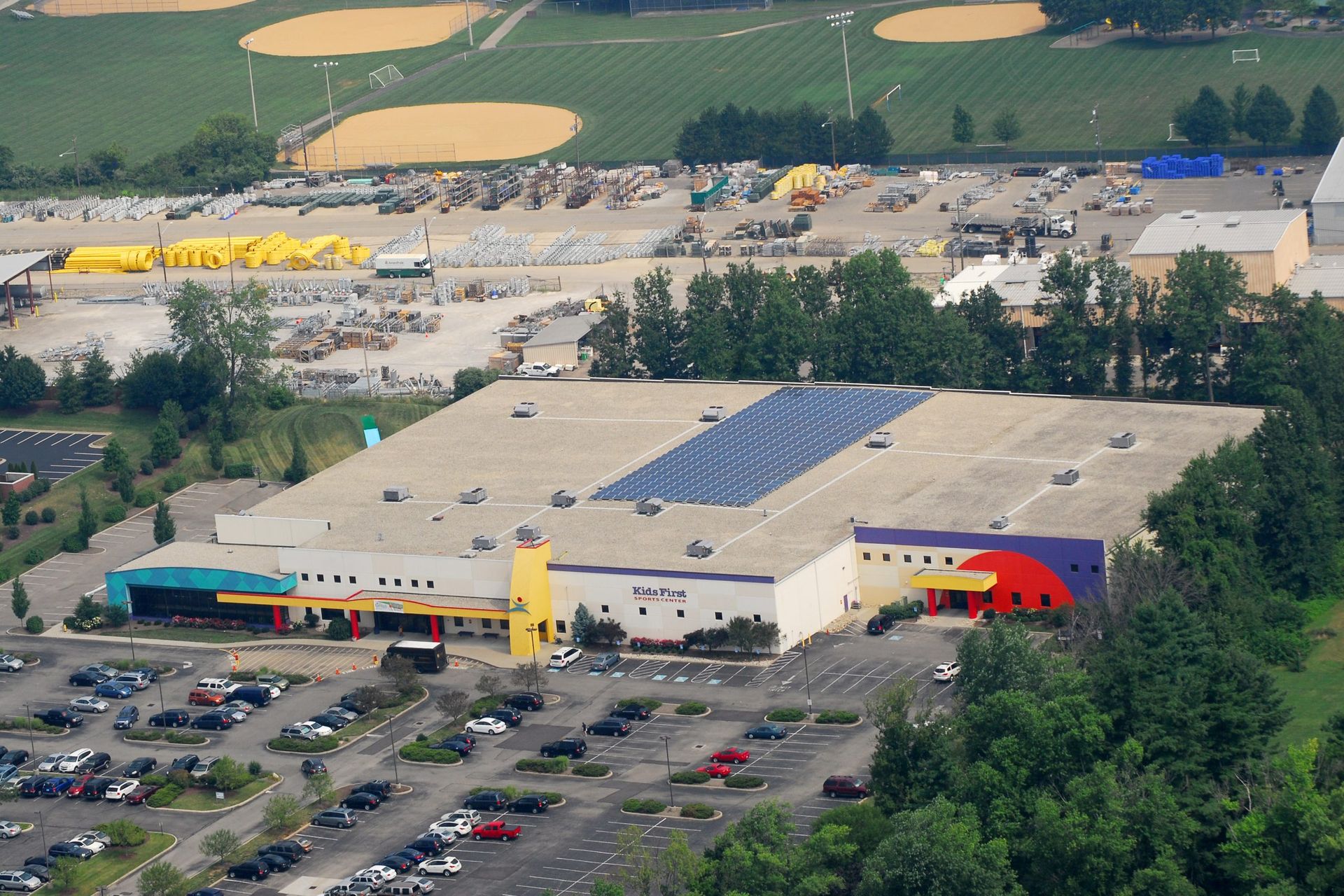 Aerial view of a large retail store with solar panels, parking lot, and farmland nearby.