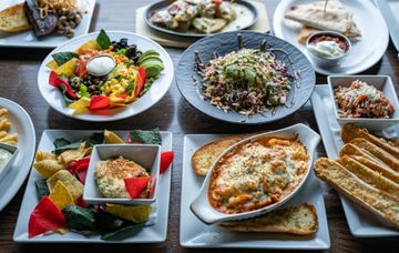 Assorted colorful dishes and appetizers arranged on a table in small plates and bowls