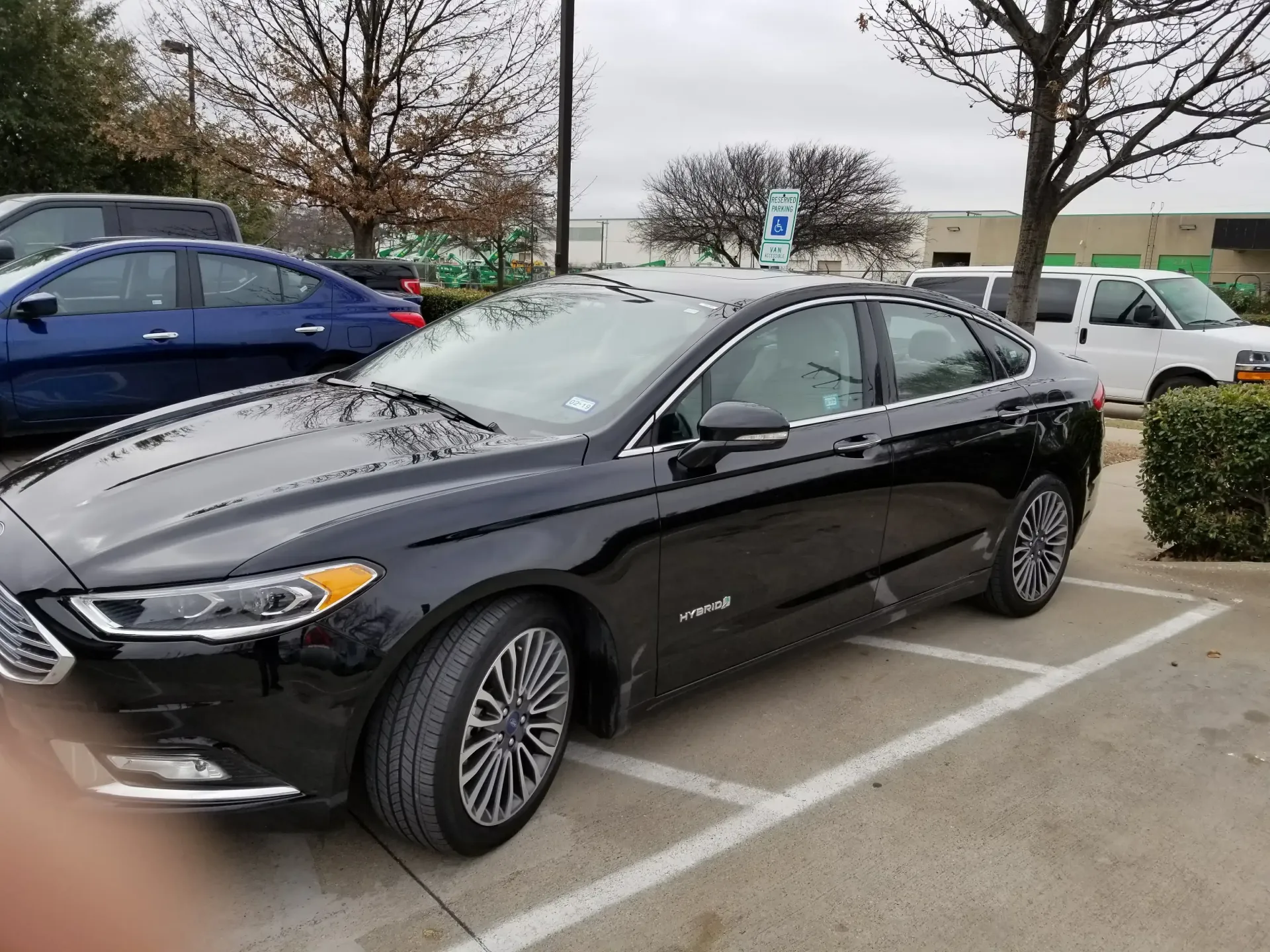 A black Ford Fusion sedan parked in an outdoor lot on an overcast day.