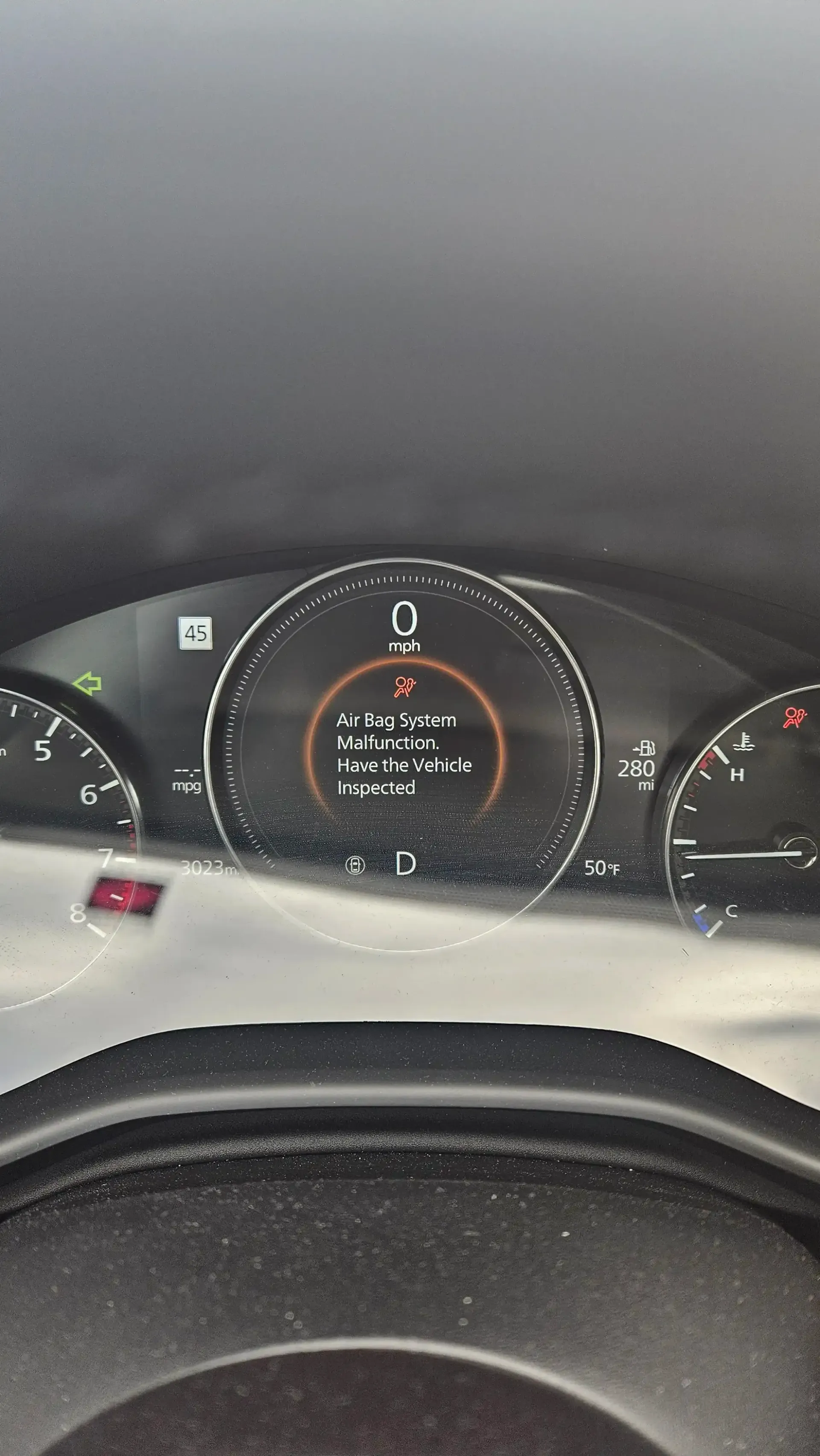 Vehicle dashboard showing an Airbag System Malfunction warning light and message.