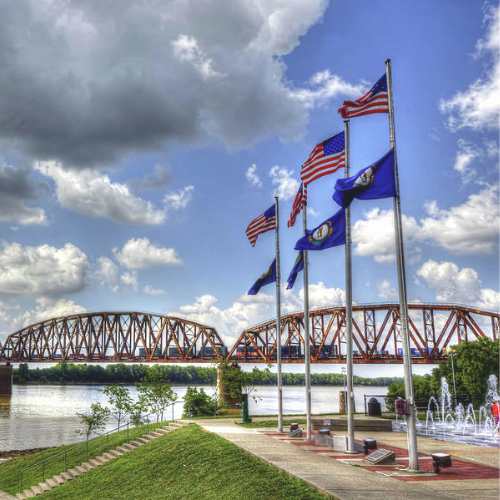 Riverfront view of Henderson, Kentucky with flags and bridge