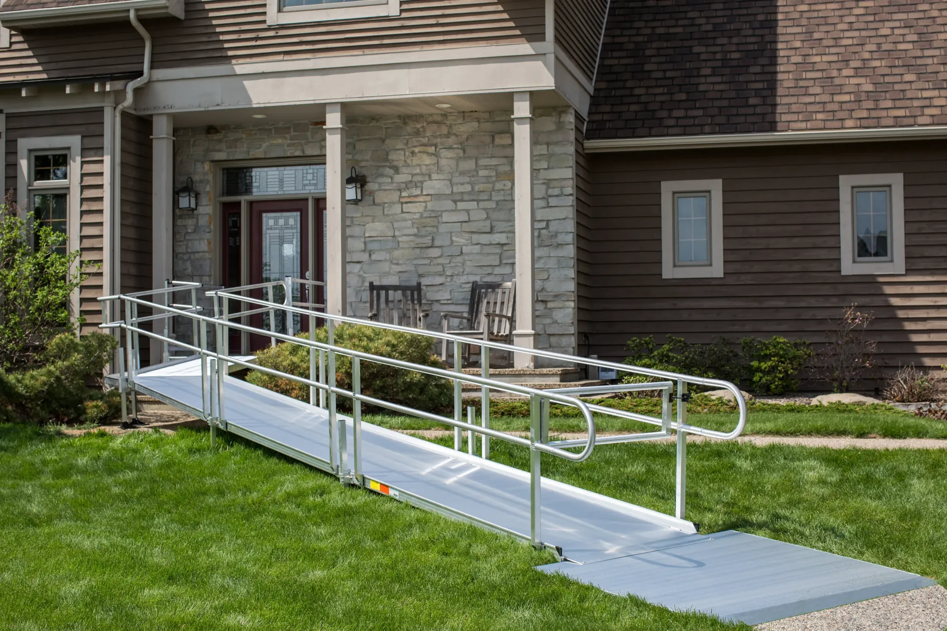Accessible entrance with a metal ramp leading to a stone building doorway