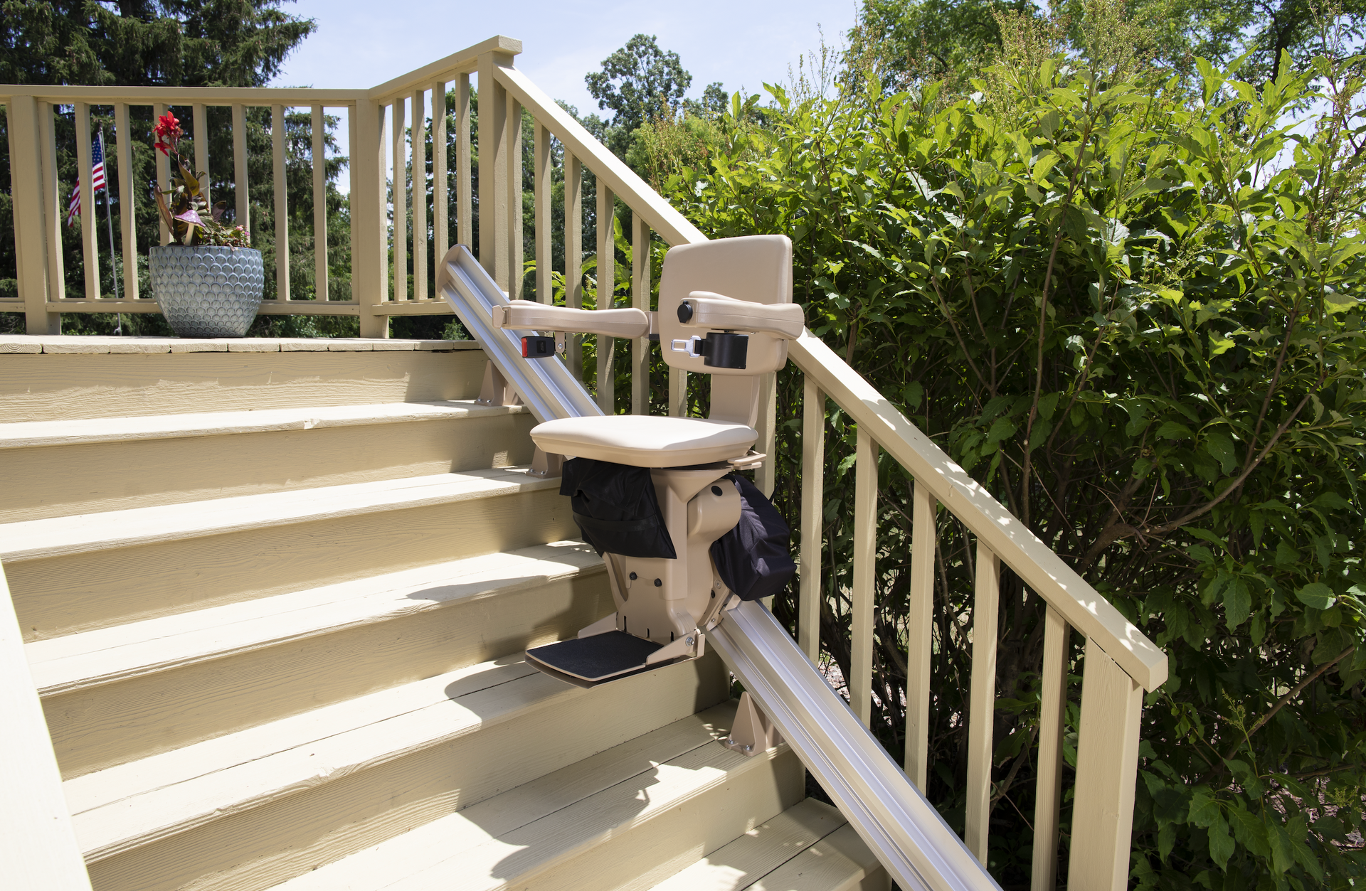 An outdoor straight stair lift attached to the side of the stairs by Altamira Ltd.