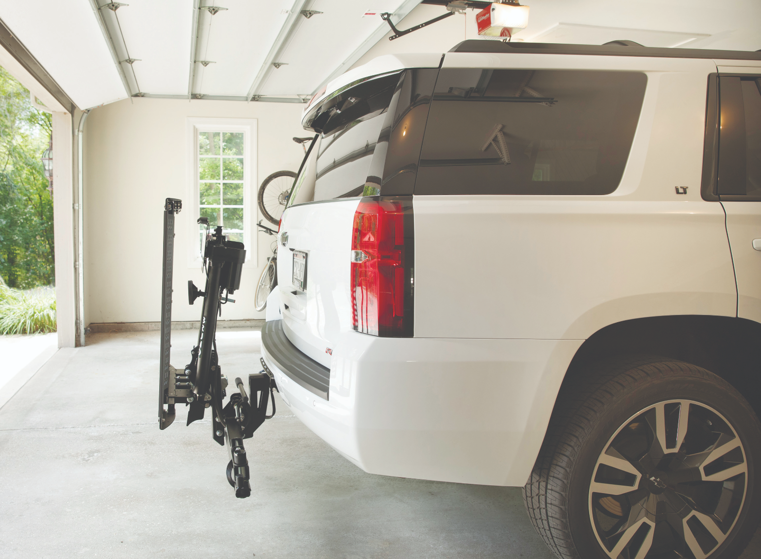 A white SUV carrying a mobility device on a Bruno exterior vehicle lift installed by Altamira Ltd.