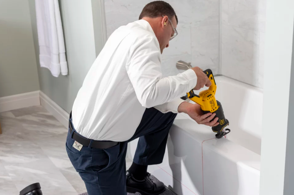 An Altamira Ltd. worker installing a tub cut in a bathtub.