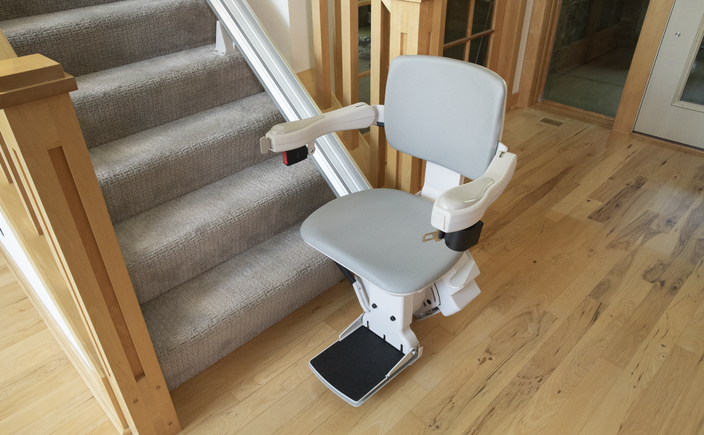 A stair lift Installed by Altamira Ltd. is sitting on a set of stairs.
