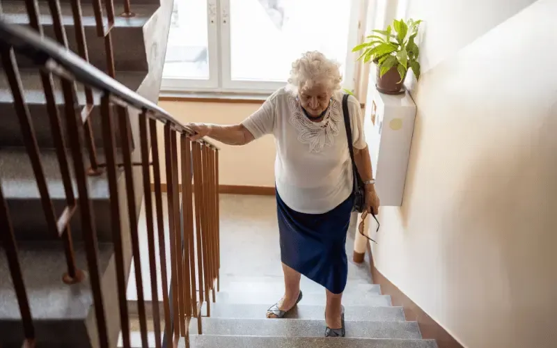 Person placing both feet on each stair step while climbing one step at a time