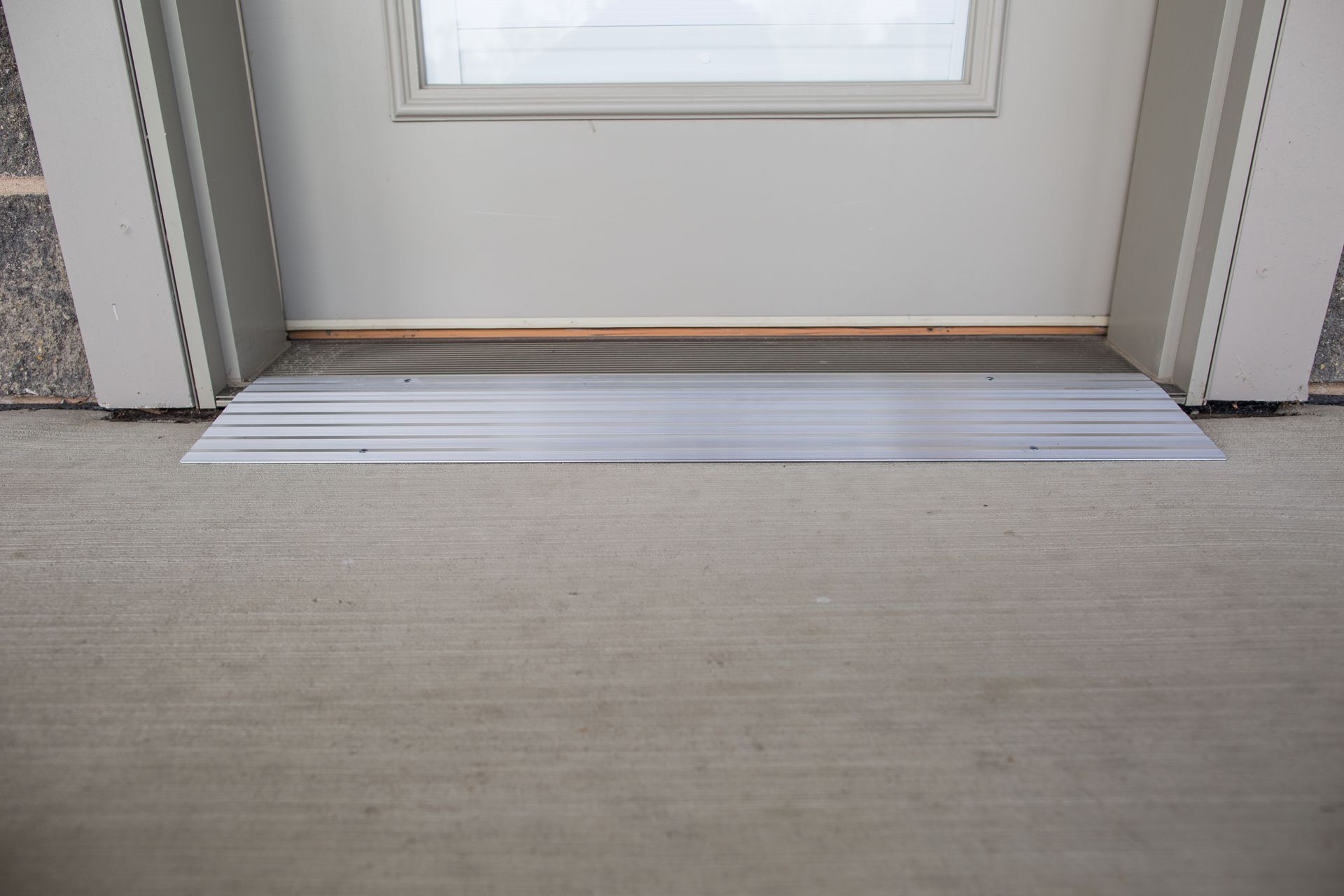 A door with an EZ-Access threshold ramp in front of it