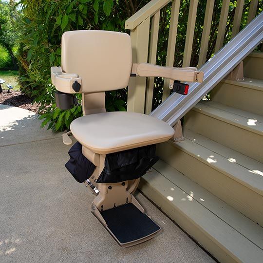An outdoor stairlift on the side of a set of stairs, installed by Altamira Ltd.