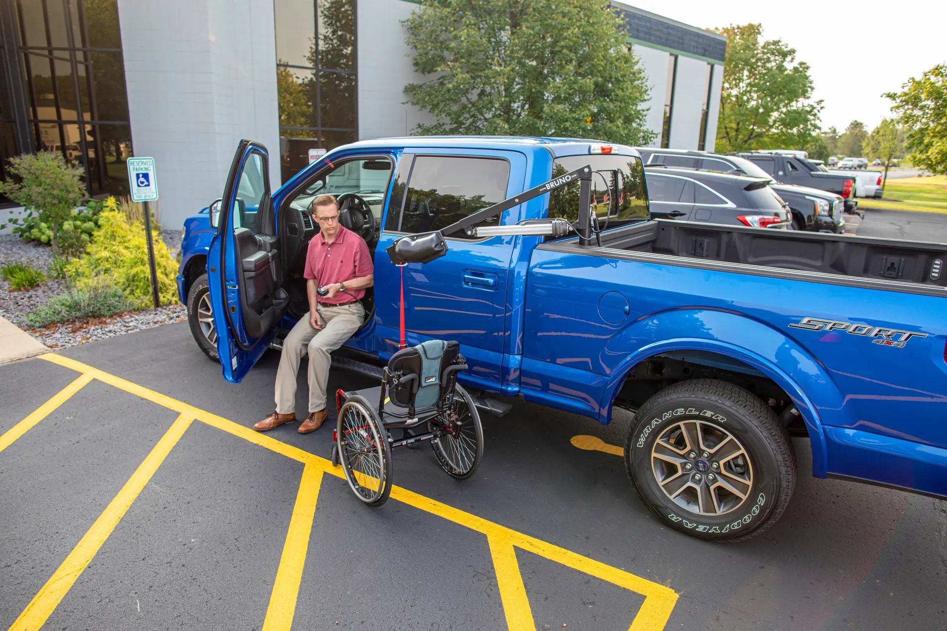 A man lowering a wheelchair from a pickup truck bed using a Bruno Out-Rider lift installed by Altamira Ltd.