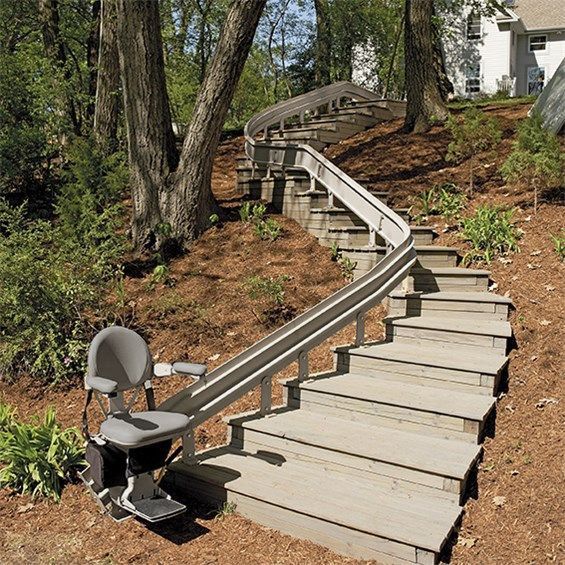 A set of outdoor stairs with an outdoor curved stairlift by Altamira Ltd.
