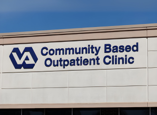 A community-based outpatient clinic sign on the side of a building.