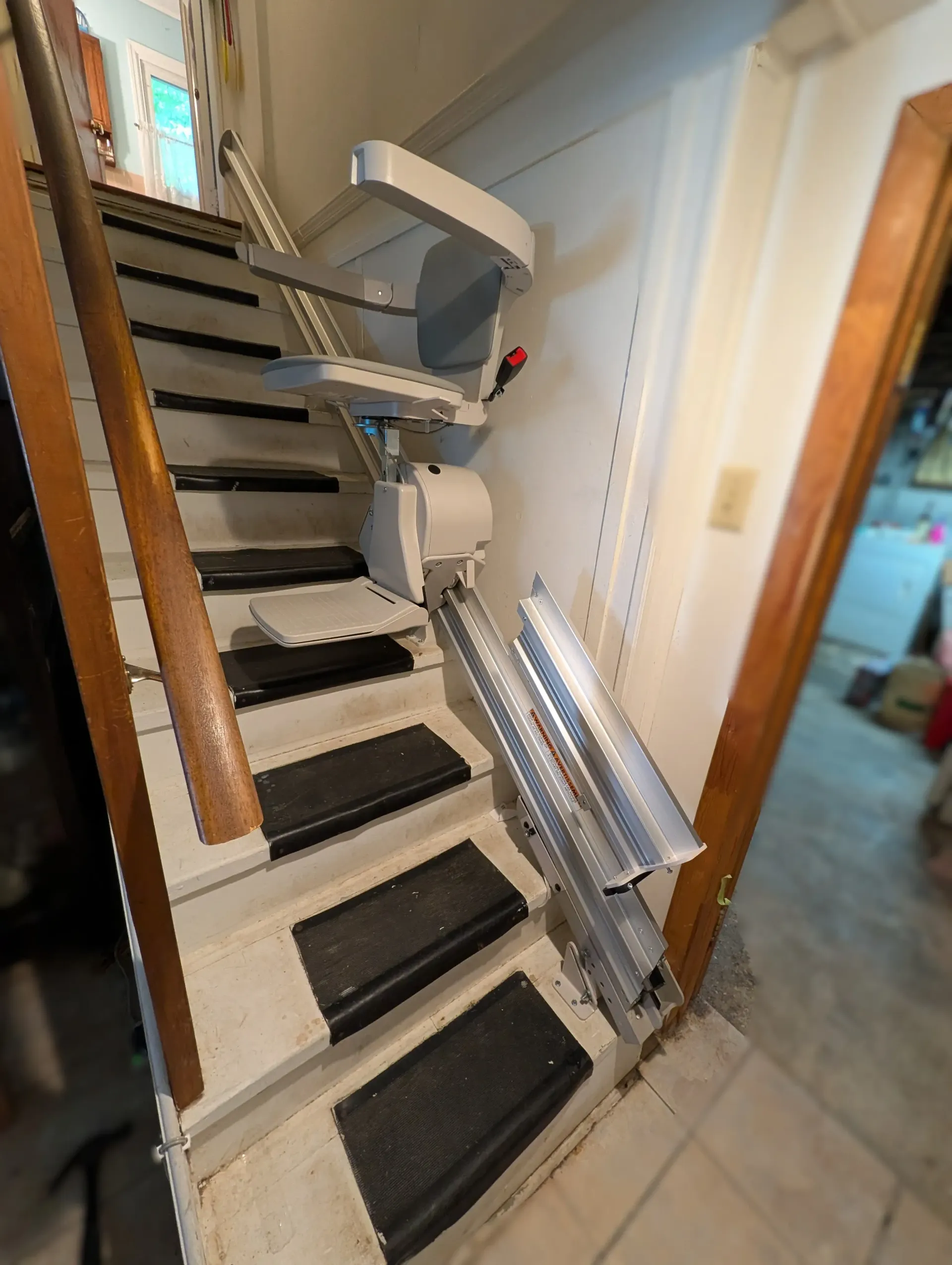 Basement stairlift with a power folding rail