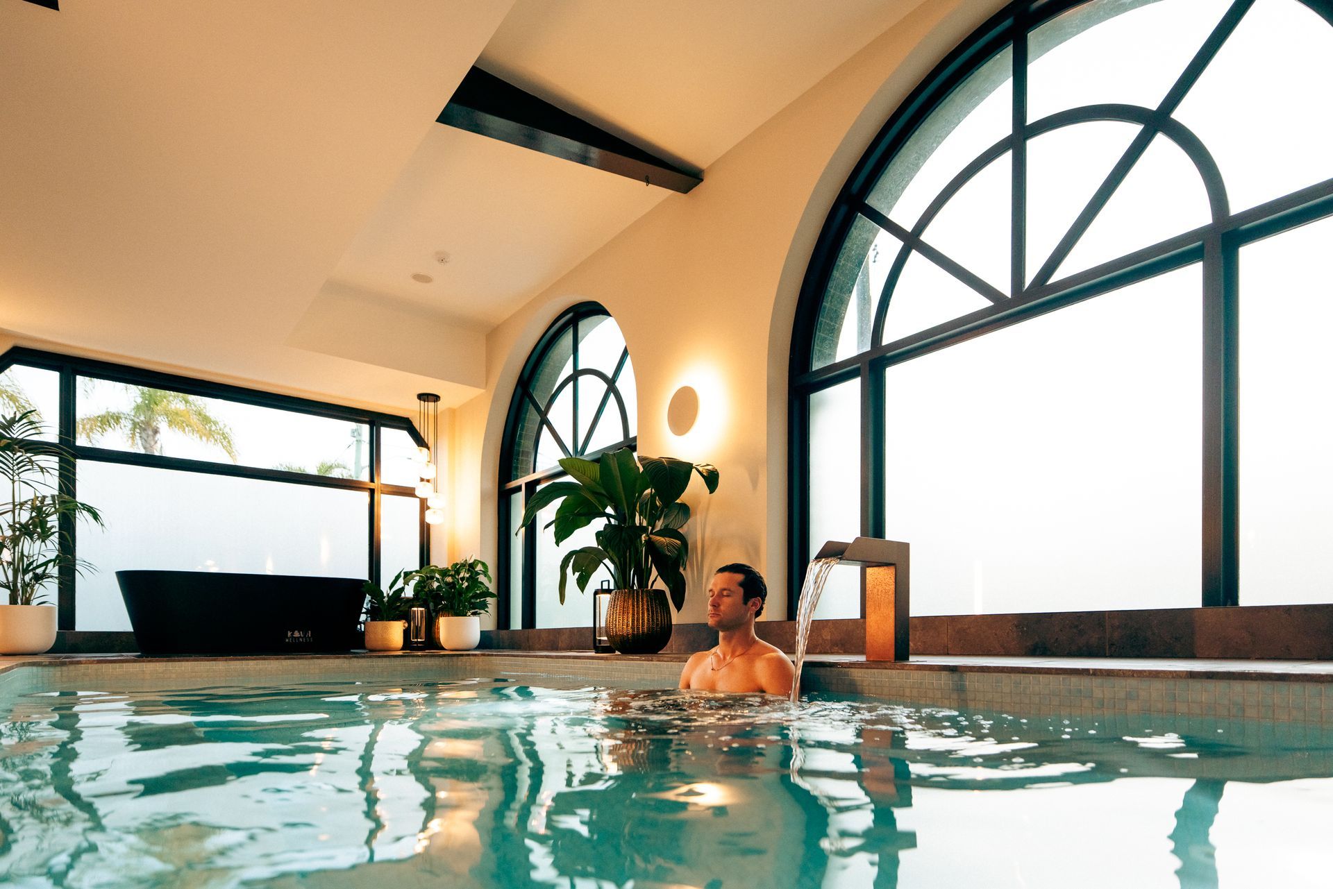 Man meditating in a mineral pool soak. Bathhouse north shore sydney