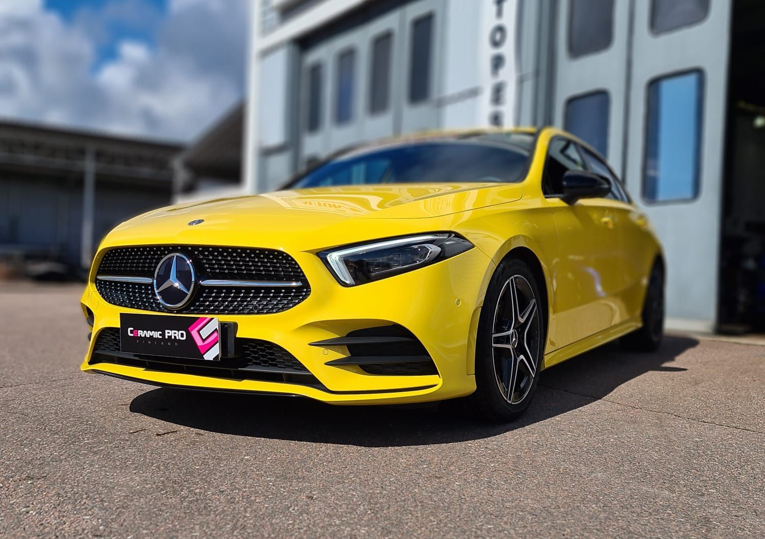 Keltainen mercedes benz a -luokka on pysäköity rakennuksen eteen.