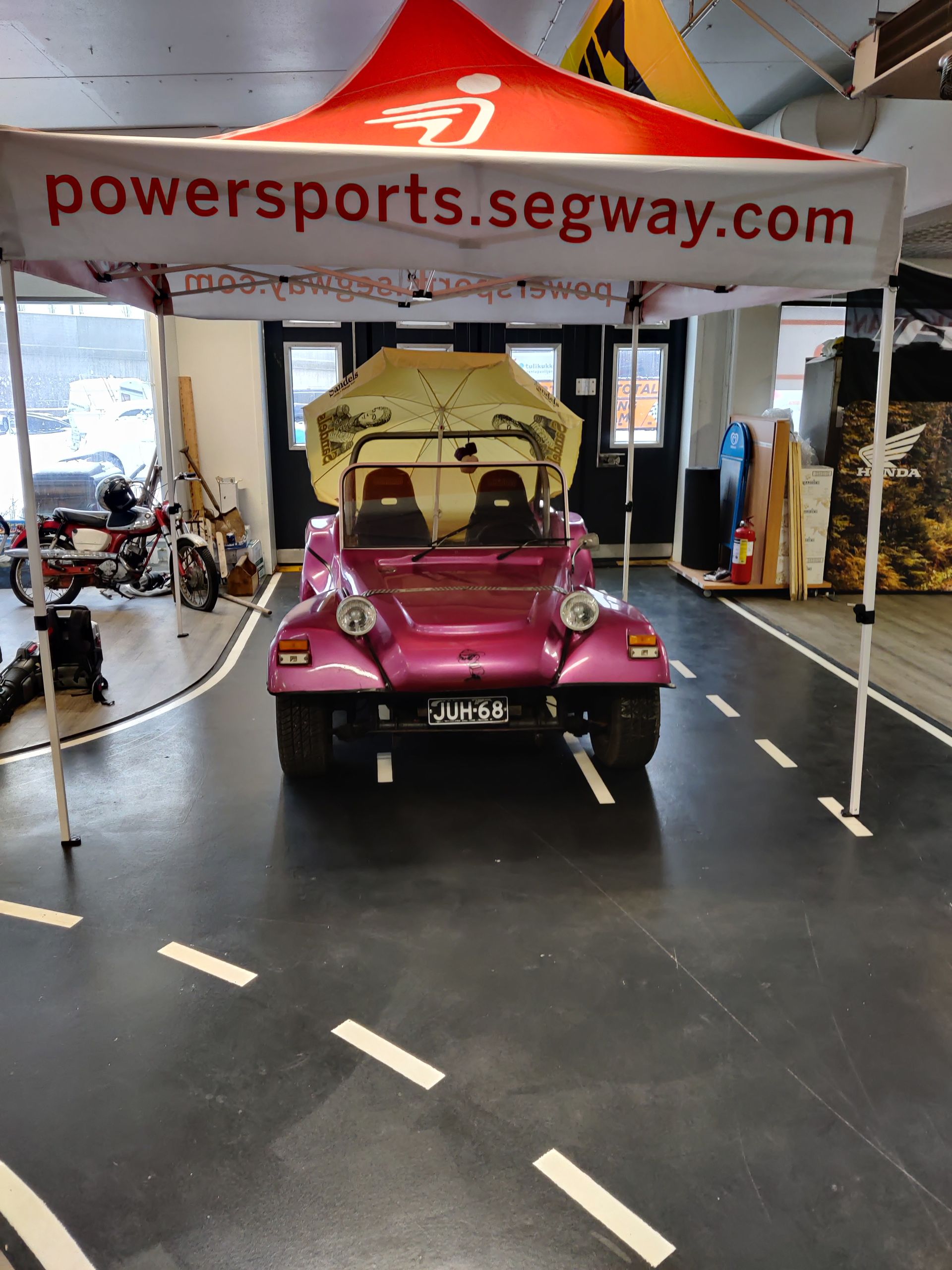 Pinkki buggy on pysäköity powersports segway -teltan alle