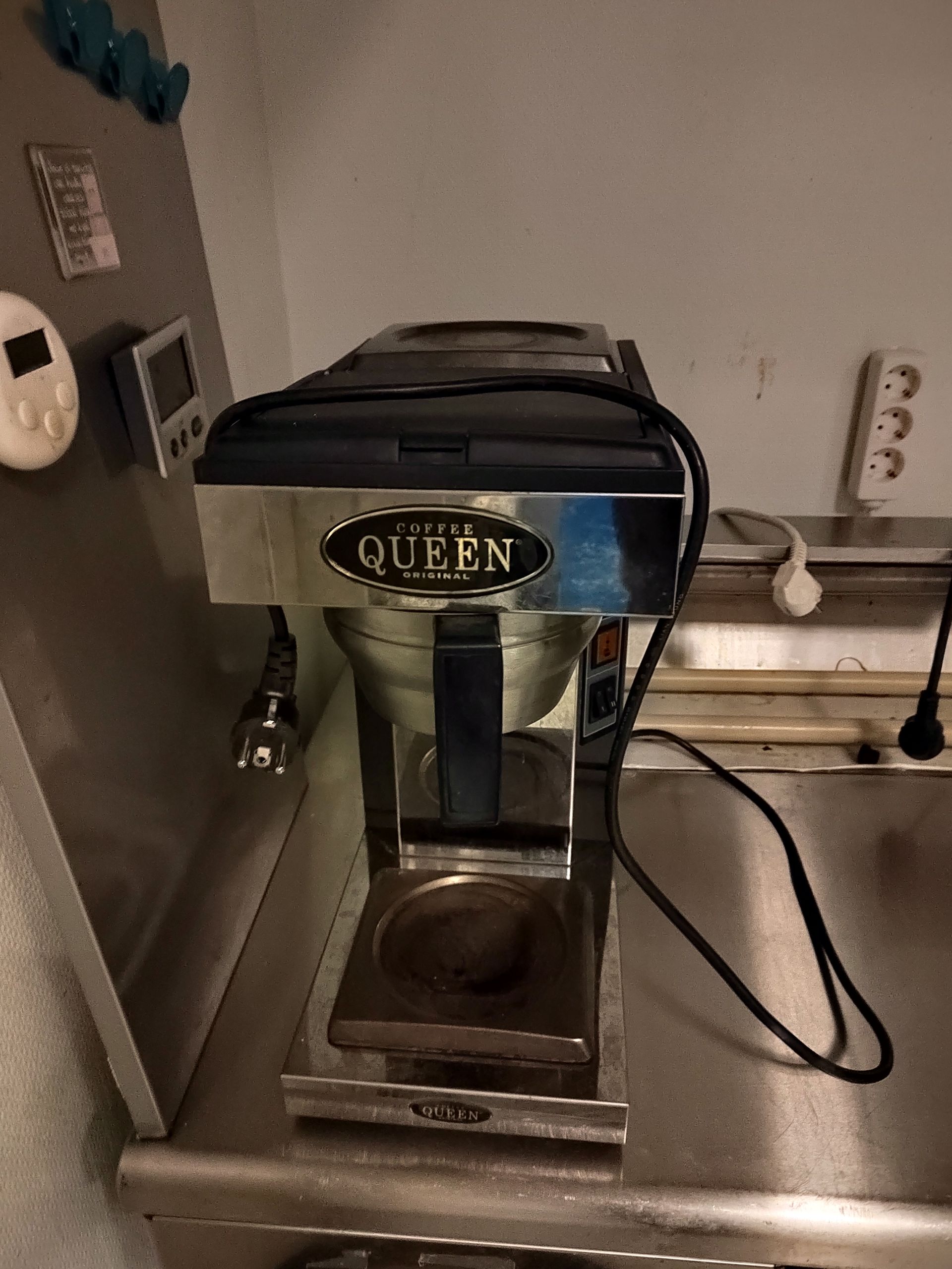 Kahvinkeitin istuu ruostumattomasta teräksestä valmistetun tiskin päällä.