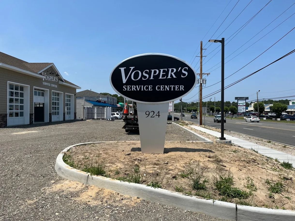Vosper’s Sewing Center roadside sign with address 924 on a sunny street corner