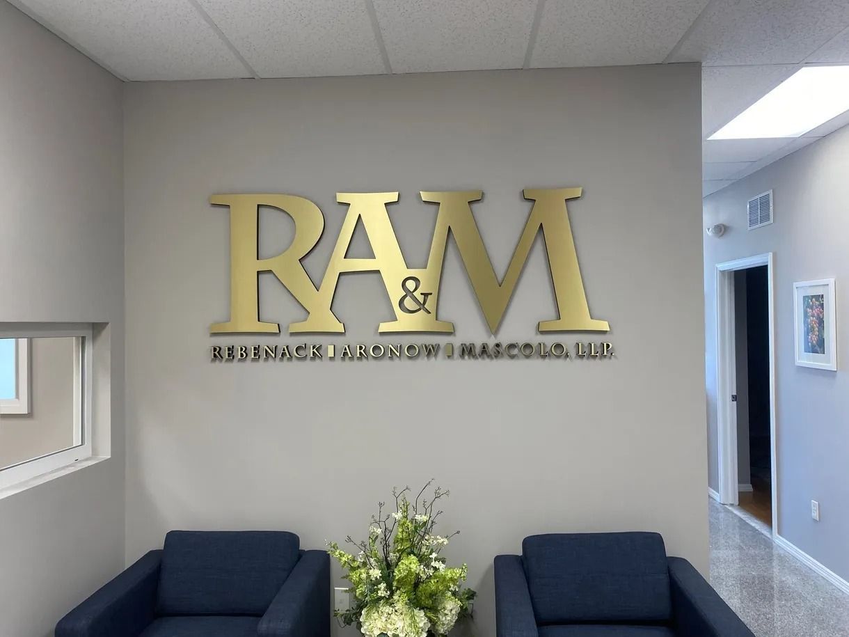 R&M office lobby sign above dark blue seating and flower arrangement
