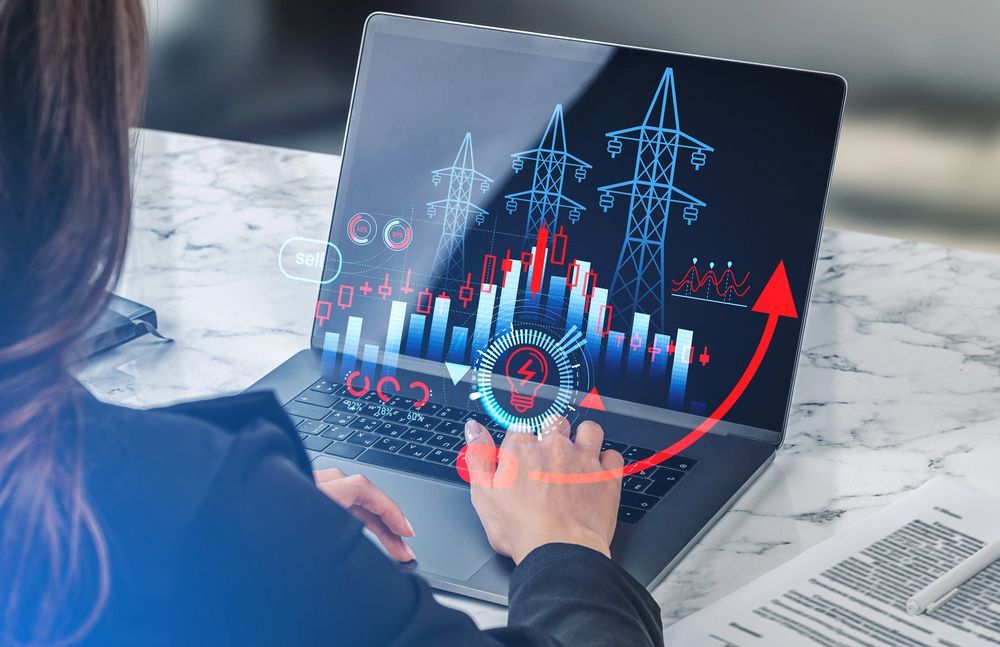 Persona usando una computadora portátil con gráficos financieros y una flecha roja ascendente en la pantalla.