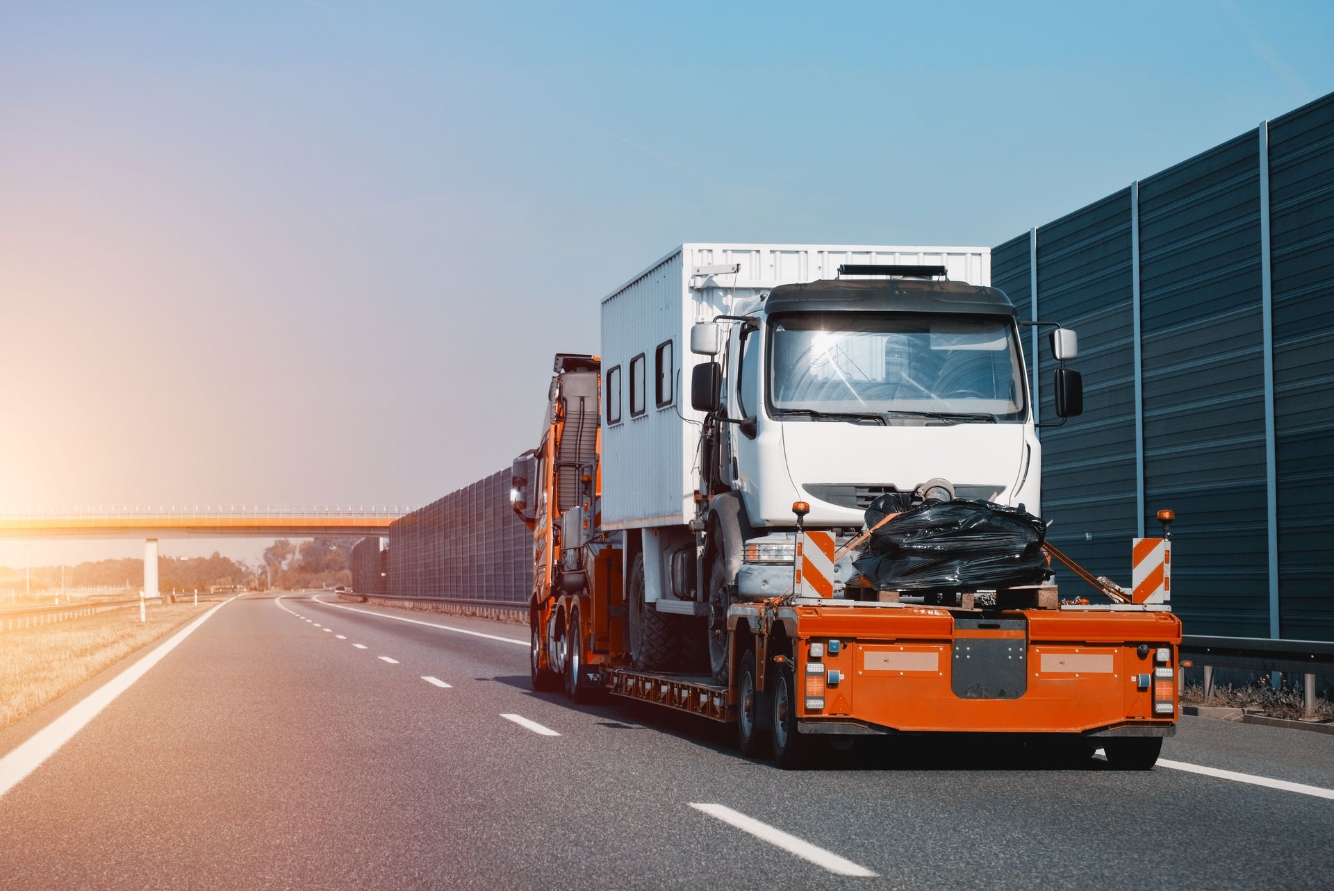 A side view of the towing truck with a brand-new commercial vehicle.