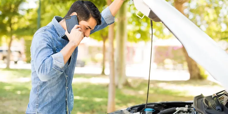 Man On The Phone While Looking To Car Engine — Camp Douglas, WI — C. L. Chase 24 Hour Towing & Recovery
