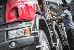 Man Checking Truck — Camp Douglas, WI — C. L. Chase 24 Hour Towing & Recovery Man Checking Truck — Camp Douglas, WI — C. L. Chase 24 Hour Towing & Recovery