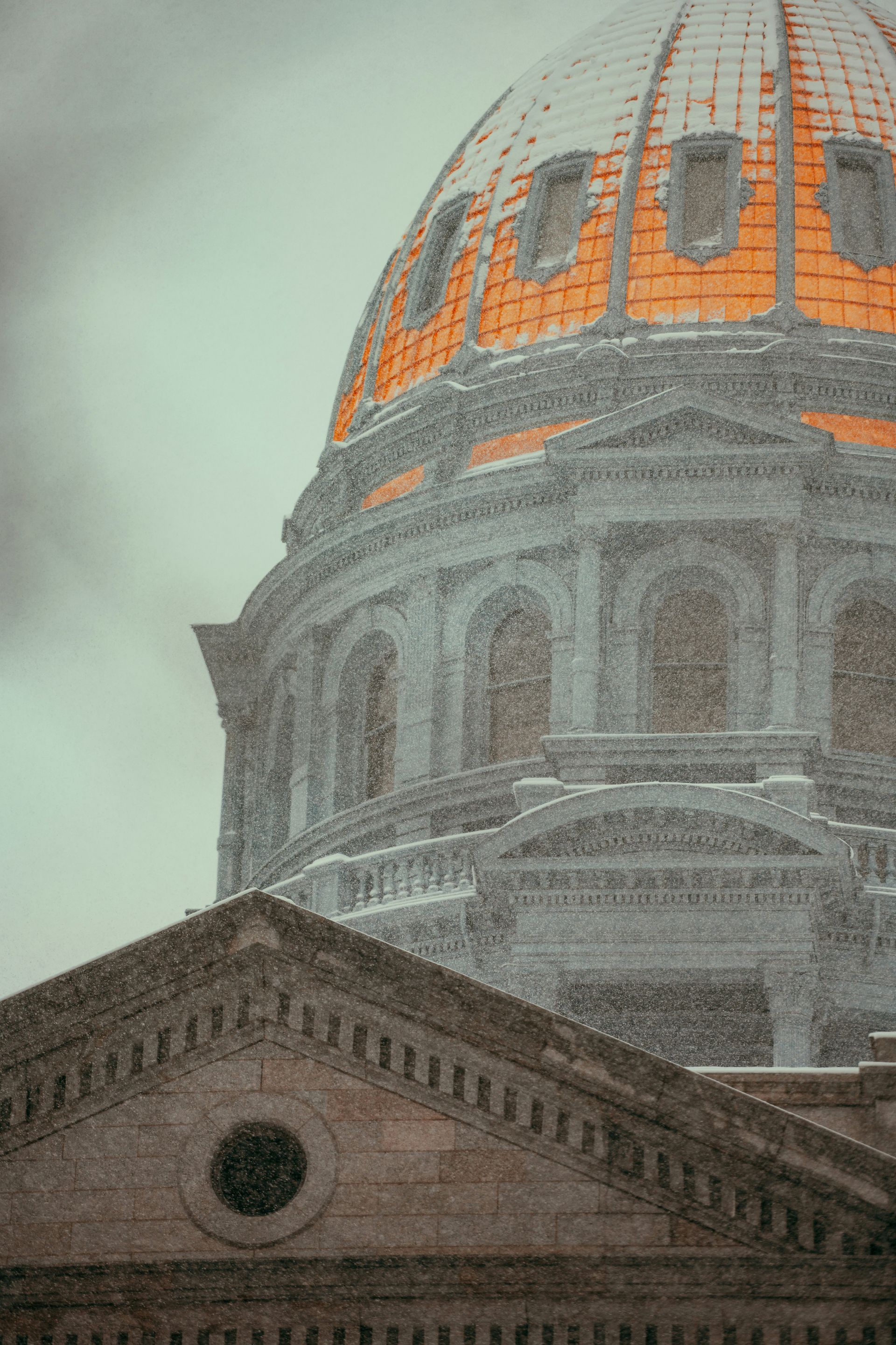 The dome of the capitol building is covered in snow.