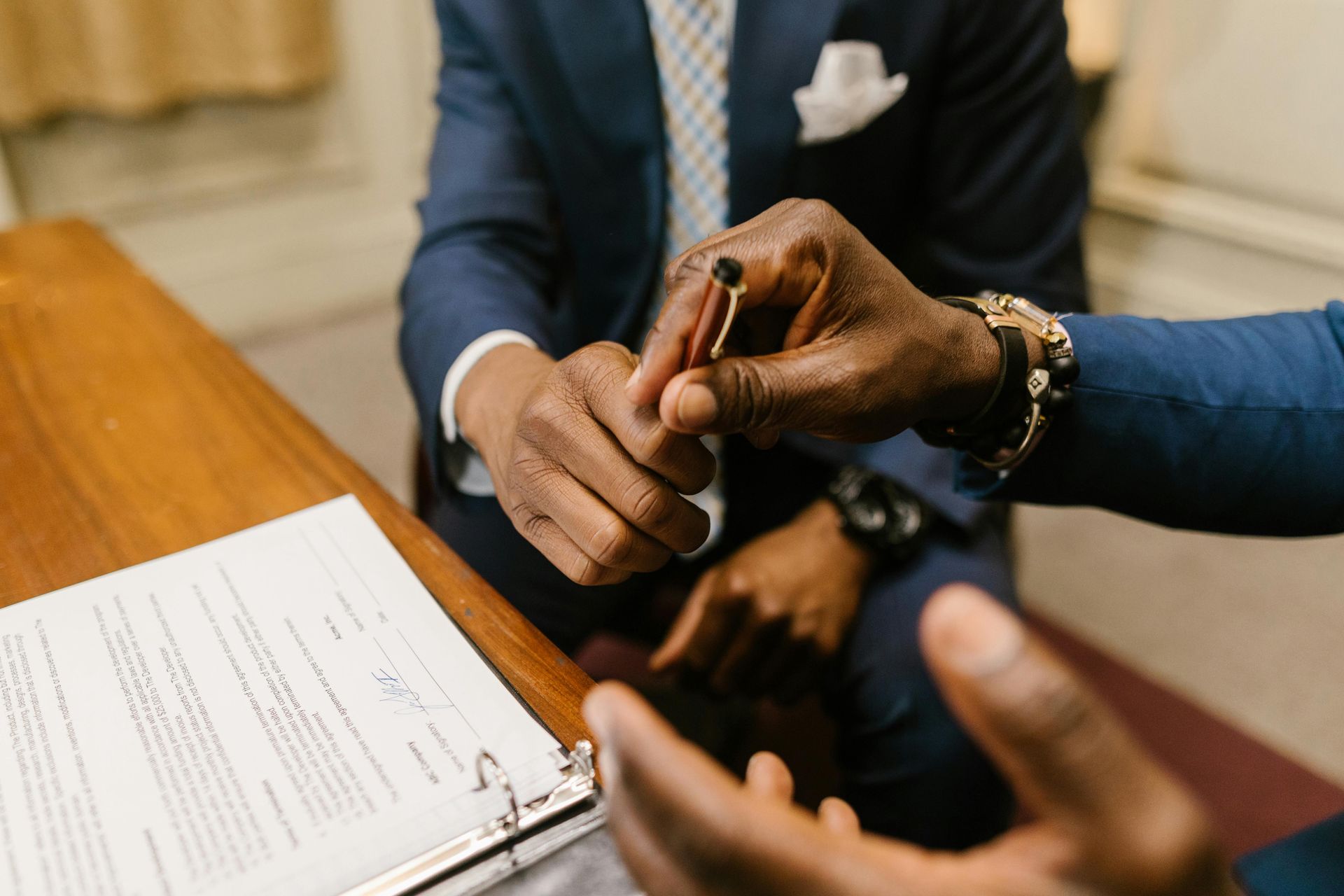 A man in a suit is putting a ring on another man 's finger.