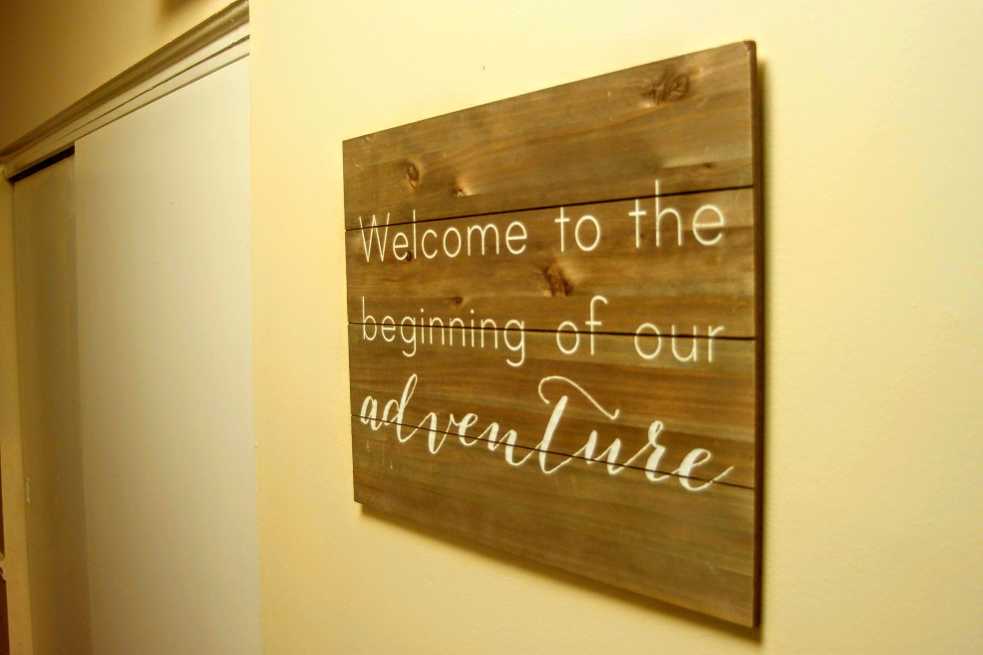 A wooden sign that says welcome to the beginning of our adventure