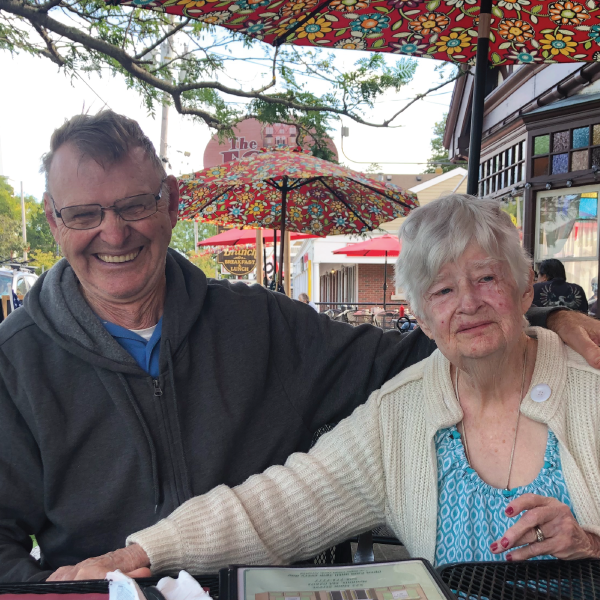 A man and a woman are sitting at a table under umbrellas