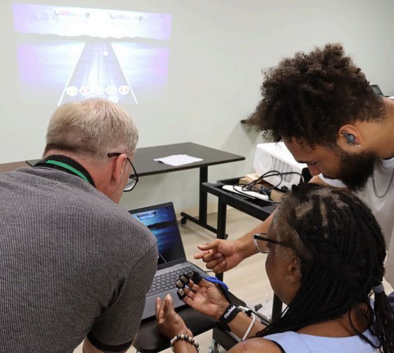A group of people are using adaptive technology, the Music Glove