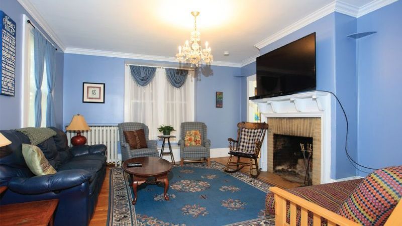 A living room with blue walls and a fireplace