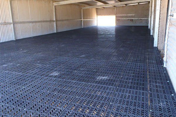 A large empty room with a black floor and white walls