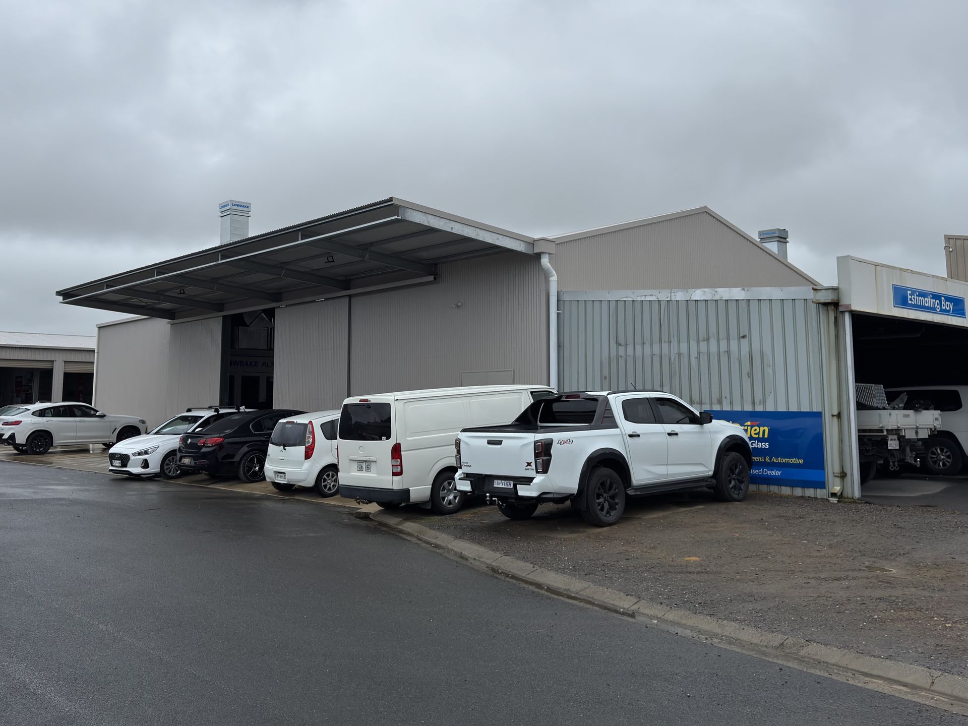 a shed with cars parked under the verandah