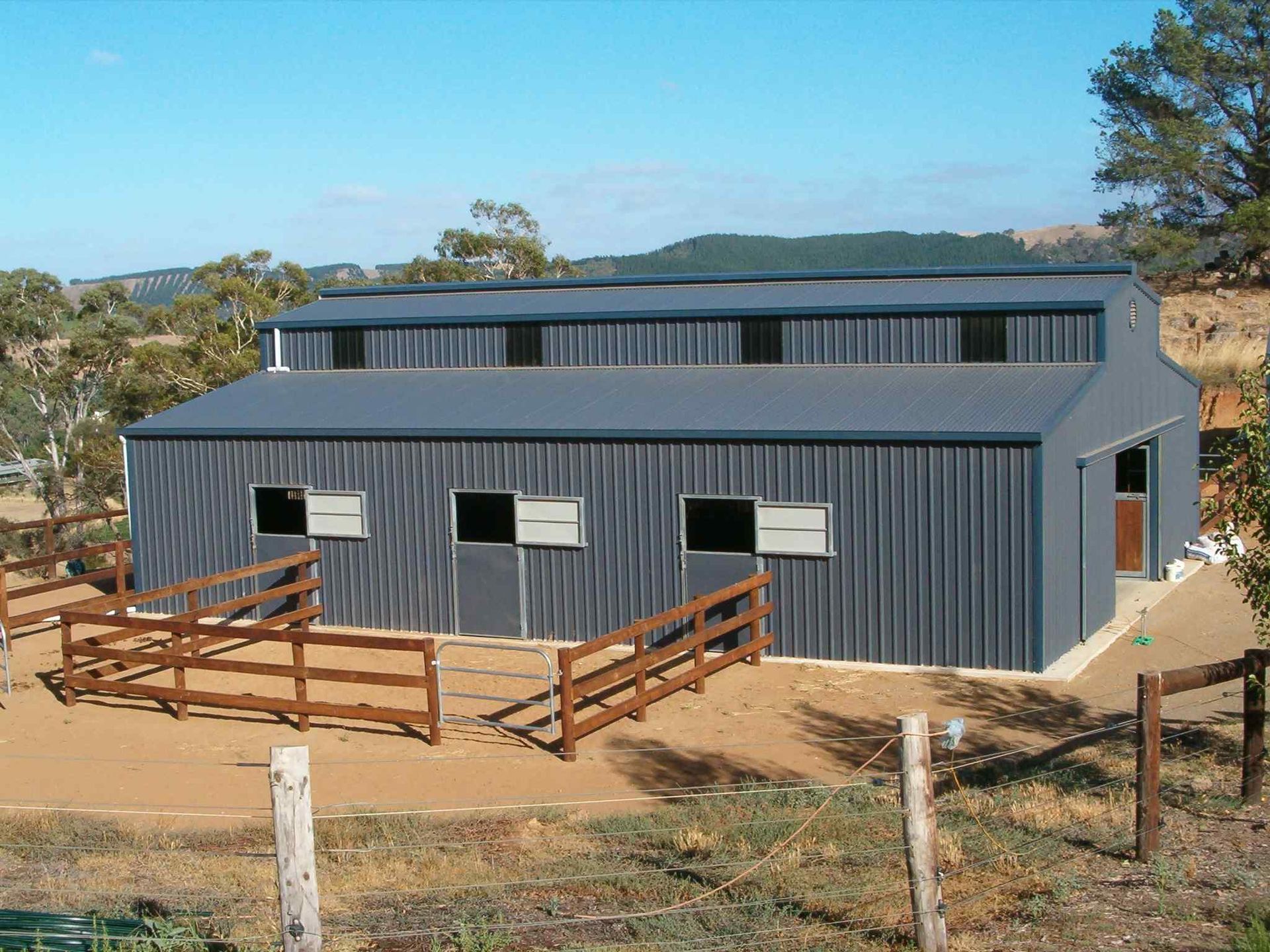 A large barn with a wooden fence around it