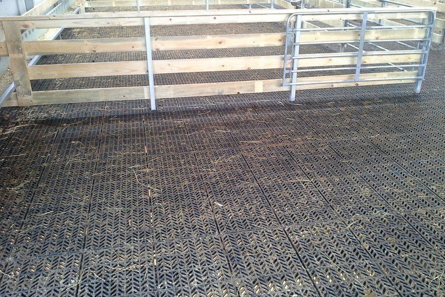 A wooden fence is surrounded by a plastic mat.