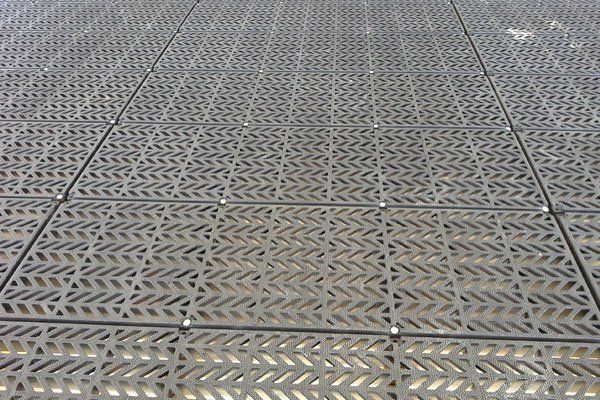A close up of a metal floor with holes in it.