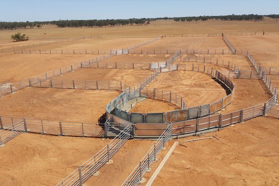 An aerial view of a fenced in area in the middle of a desert.