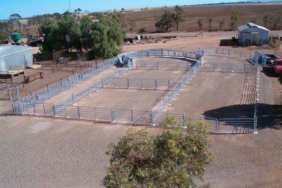 An aerial view of a fenced in area with trees in the background