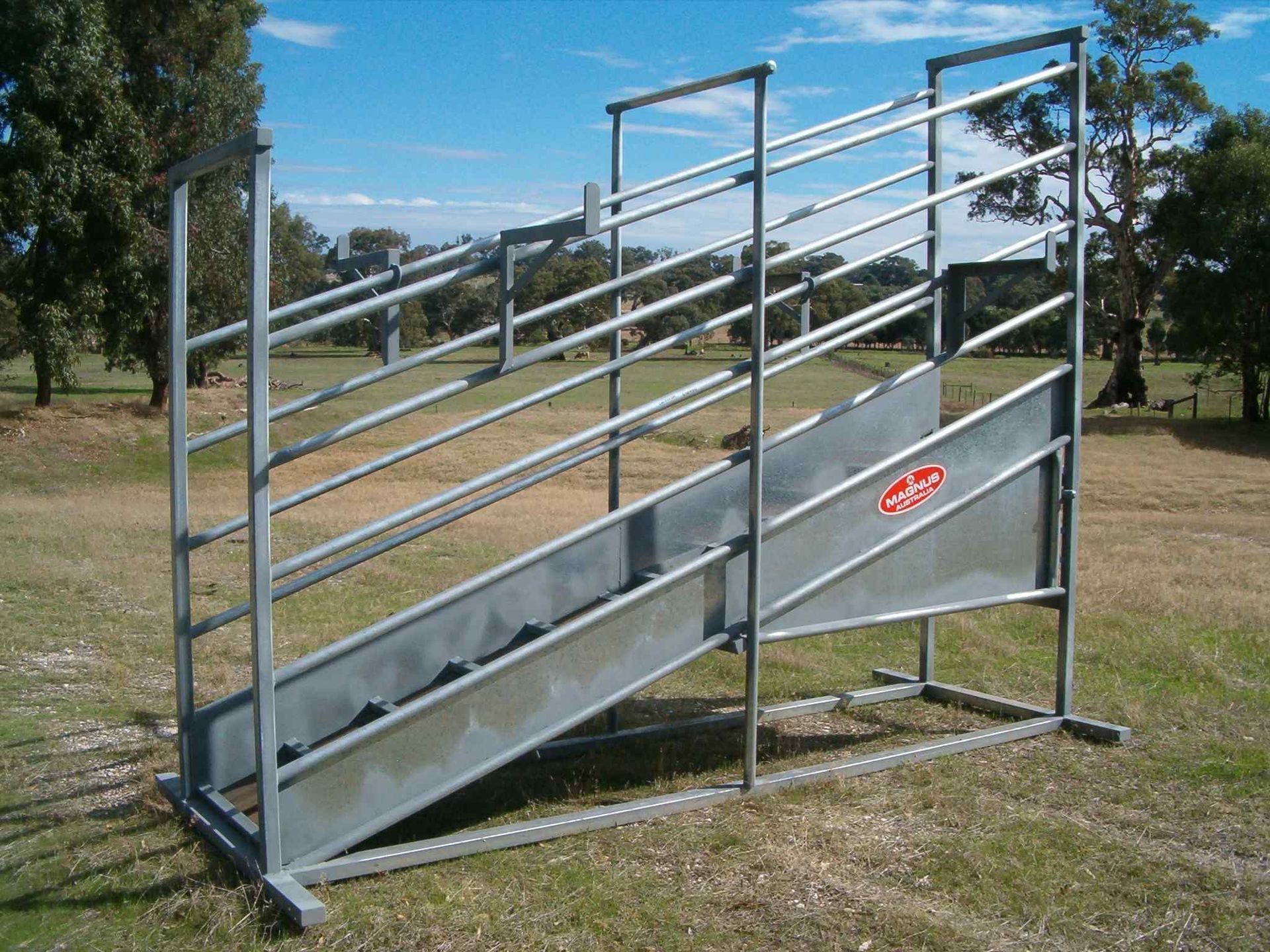 A metal ramp is sitting in the middle of a grassy field
