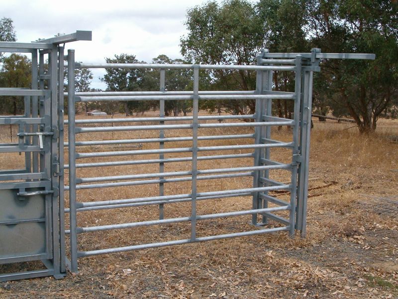 A blue metal fence is sitting on top of a dirt field.