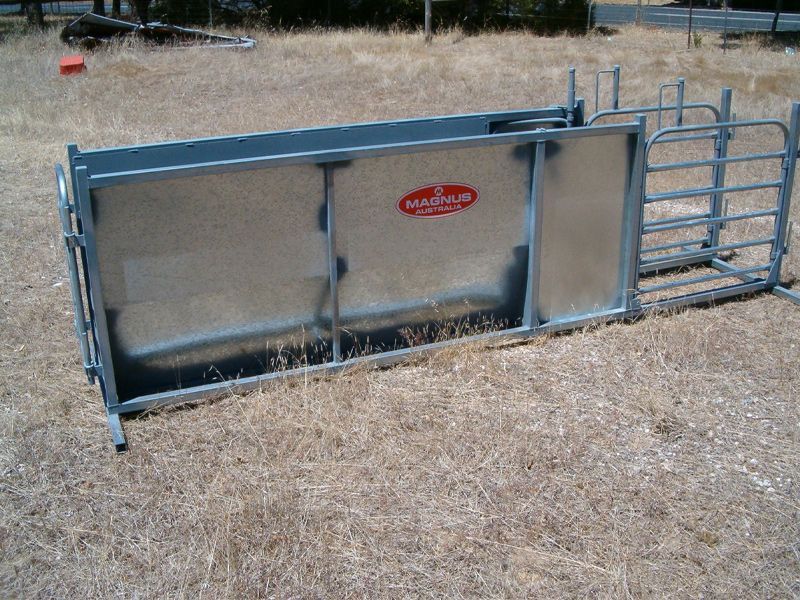 A metal fence is sitting on top of a dry grass field.