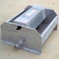 A metal container is sitting on top of a concrete surface.