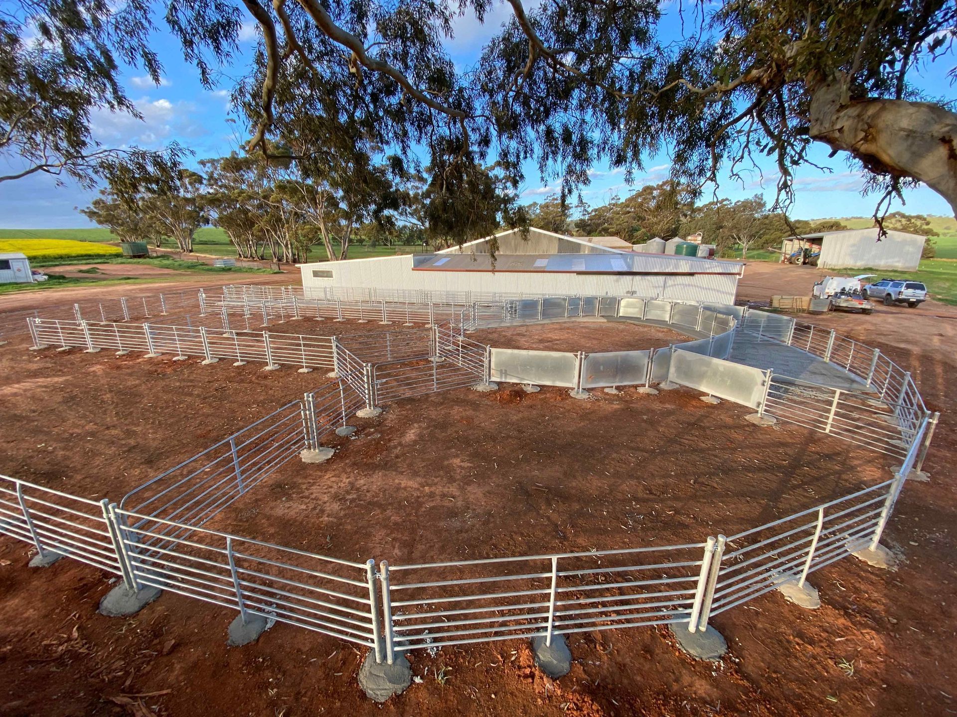 An aerial view of a fenced in area with a tree in the background.
