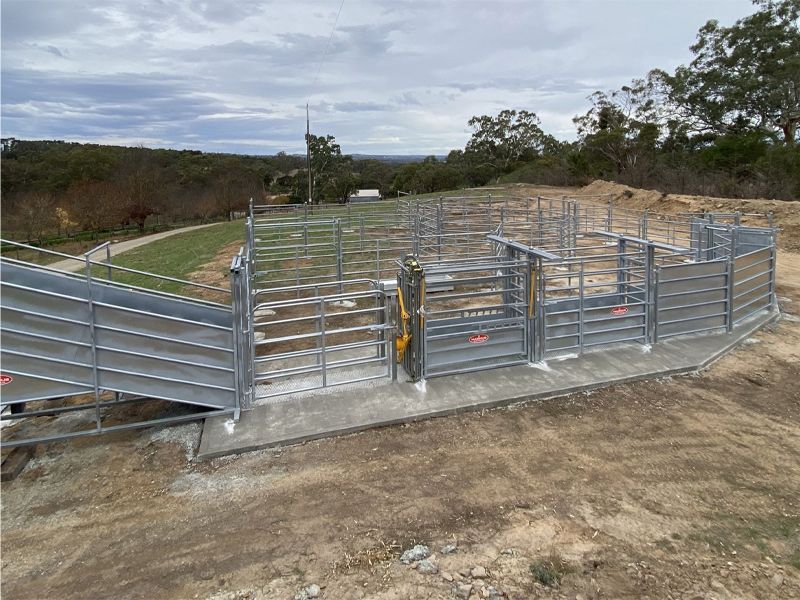 A metal fence with a wooden fence in a field