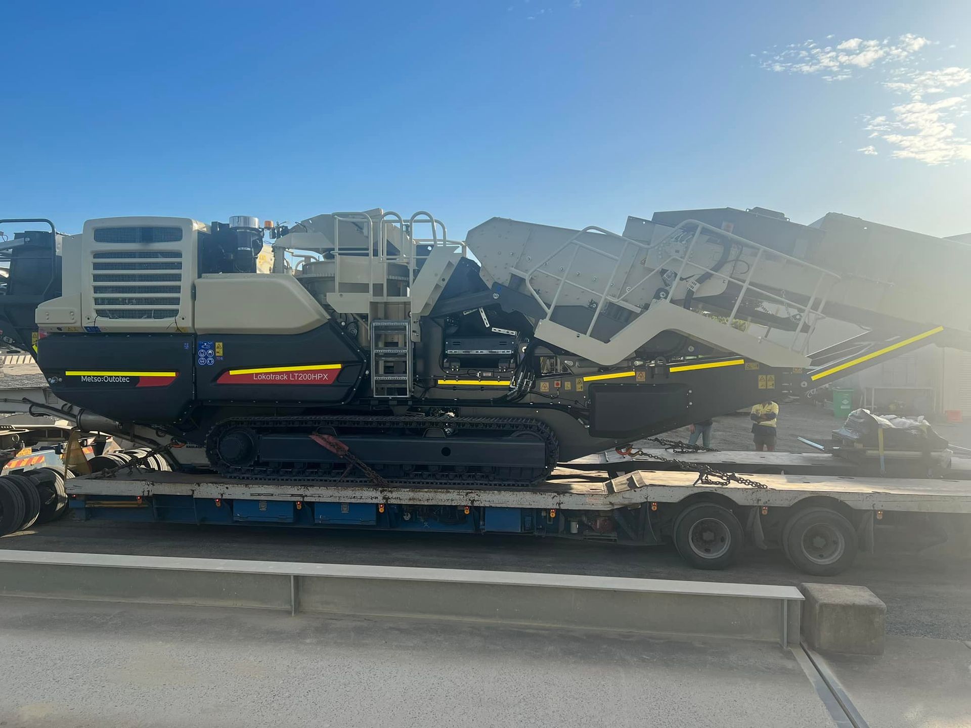 Large Industrial Machine on A Flatbed Trailer Under a Blue Sky — Barlow's Earthmoving in Yeppoon, QLD