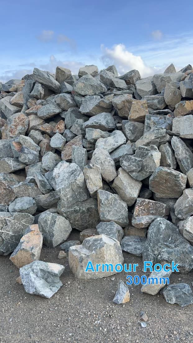 Pile of Gray and Beige Armor Rock on A Concrete Surface — Barlow's Earthmoving in Emu Park, QLD