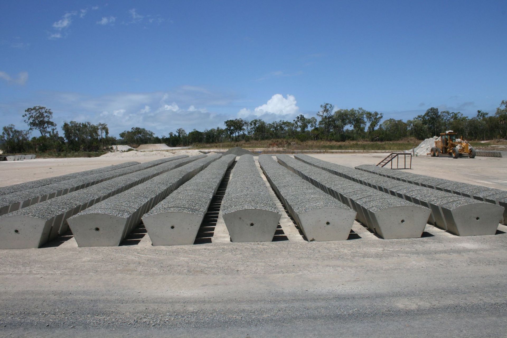 Rows of Precast Concrete Beams on A Gravel Surface Under a Blue Sky — Barlow's Earthmoving in Emu Park, QLD