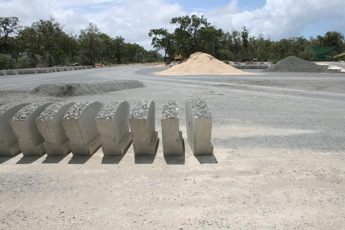 Concrete Blocks Lined Up on a Gravel Lot — Barlow's Earthmoving in Rockhampton, QLD